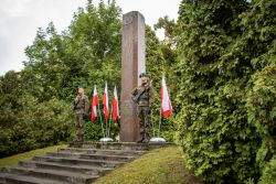 Dwóch żołnierzy z 2. Mazowieckiego Pułku Saperów stoją przy pomniku przy ul. Warszawskiej.