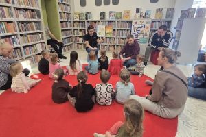 Czytanie na dywanie. Pani bibliotekarka czyta dzieciom książkę