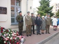 Uczestnicy uroczystości pod tablicą pamiątkową.