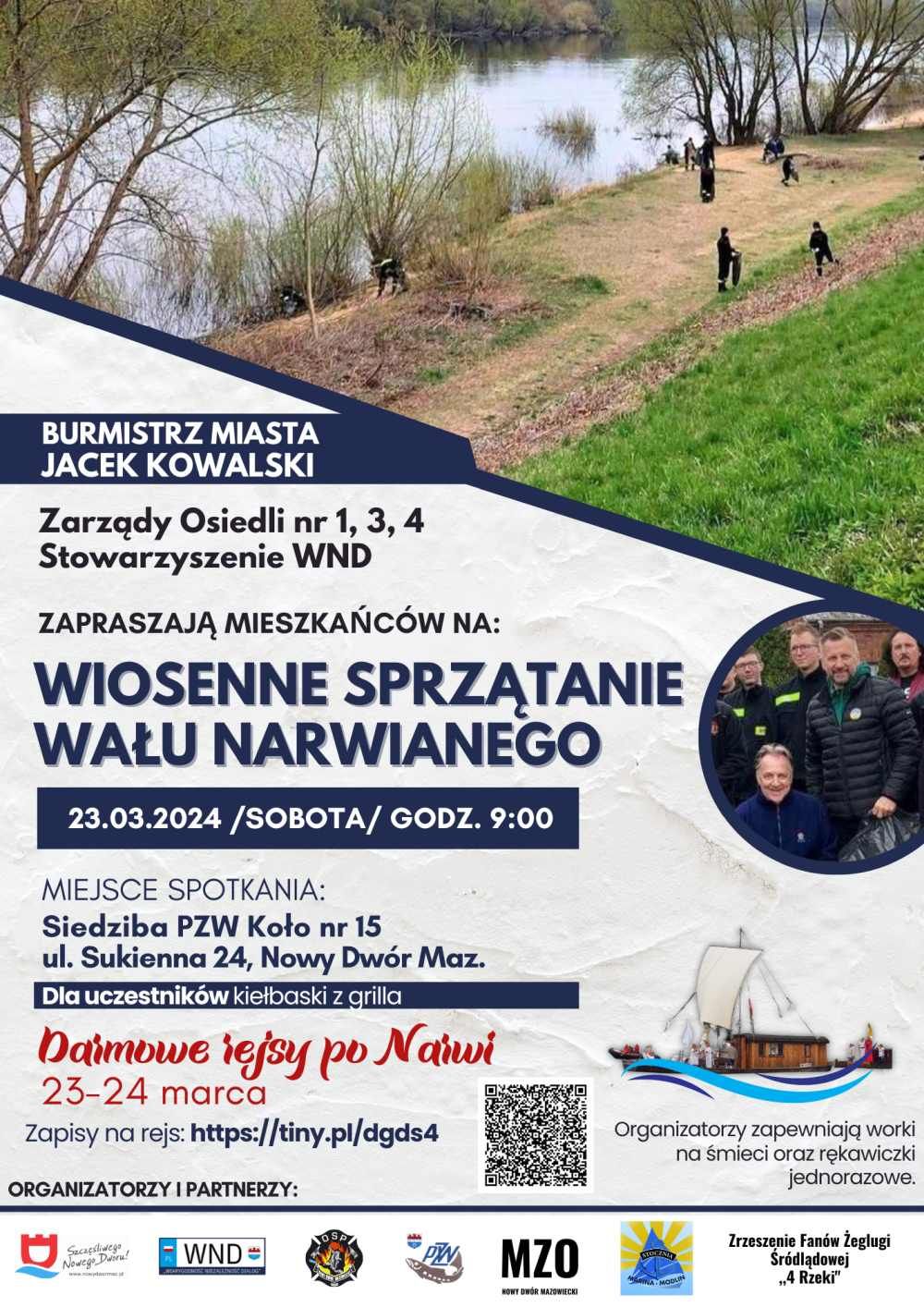 Kilka osób ubranych na czarno zbiera śmieci do czarnych plastikowych worków na terenie porośniętym trawą, przylegającym do...