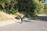 Dwóch chłopców na hulajnogach.