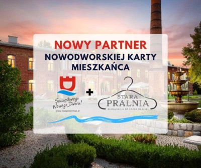 Zabytkowy budynek z czerwonej cegły szarymi oknami. Przed nim wysoki komin z czerwonej cegły i fontanna.