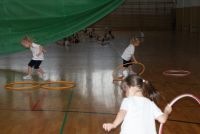Trzy dziewczynki ćwiczą z hula-hop.