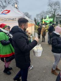 Mężczyzna idący z koszyczkiem z opłatkami.