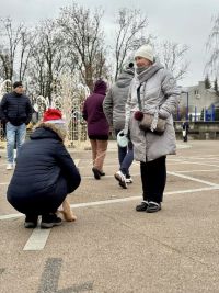 Pięć osób na placu przy dekoracyjnych elementach świetlnych.