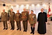 Mężczyzna w sutannie i pięciu mężczyzn w mundurach wojskowych.