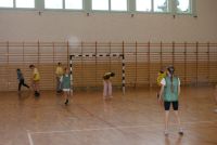Siedem dziewczynek przy bramce na hali sportowej.