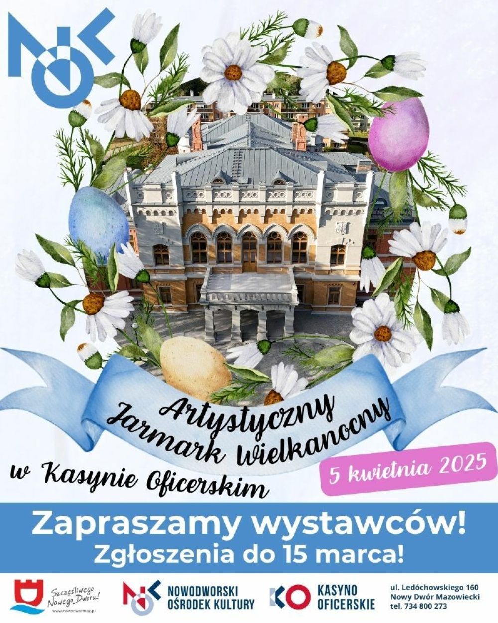 Wokół zabytkowego budynku białe kwiatki i trzy różnokolorowe pisanki.