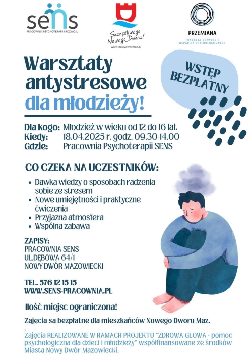 Chłopiec siedzi z podkulonymi nogami i obejmuje je swoimi rękami.