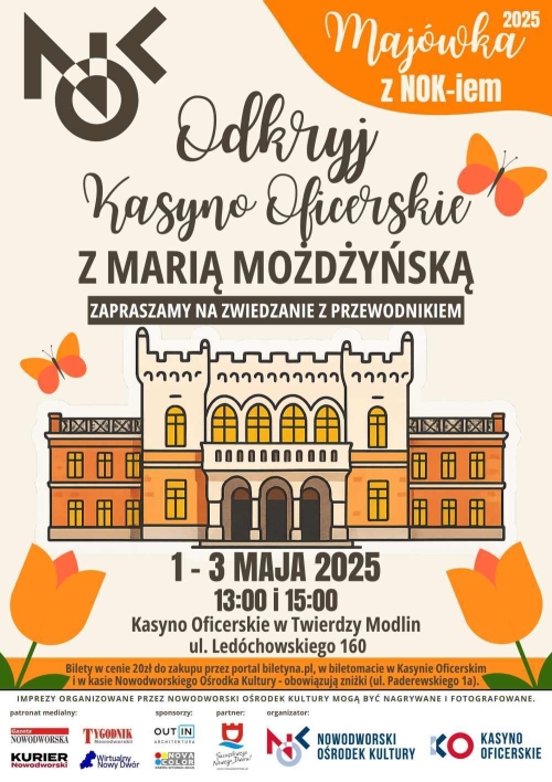 Nad zabytkowym budynkiem dwa motyle, pod nim dwa tulipany.