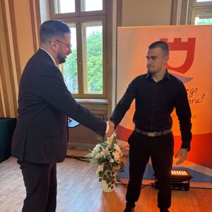 Mężczyzna i chłopiec ściskają sobie prawe dłonie.