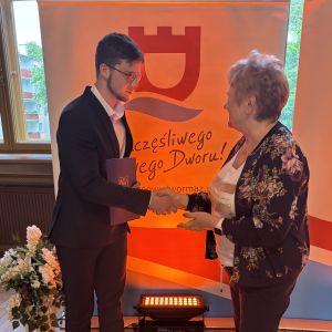 Chłopiec i kobieta ściskają sobie prawe dłonie.