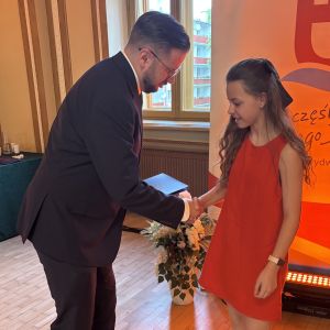 Mężczyzna i dziewczynka ściskają sobie prawe dłonie.
