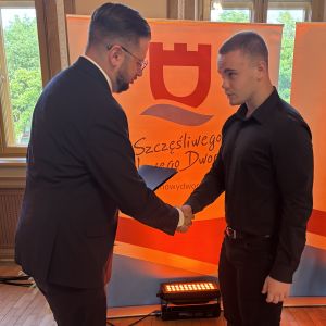 Mężczyzna i chłopiec ściskają sobie prawe dłonie.