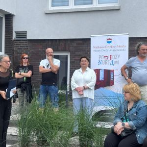 Cztery kobiety i trzech mężczyzn przed budynkiem.