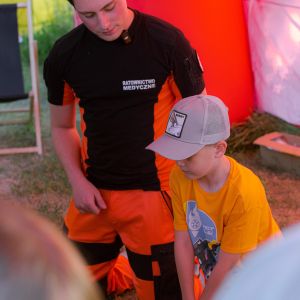 Chłopiec naciskający swoimi wyprostowanymi rękami fantoma.