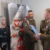 Dwóch mężczyzn w mundurach wojskowych ściska sobie prawe dłonie.