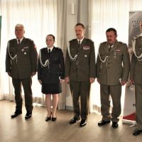 Kobieta i czterech mężczyzn w mundurach wojskowych stojących obok siebie.