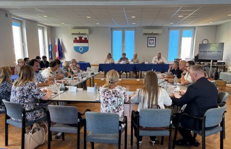 sala konferencyjna, pośrodku przy stołach siedzą radni