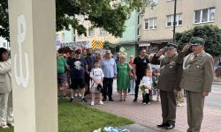 żołnierze weterani salutują przed pomnikiem, w tle zebrani mieszkańcy