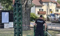wieża ze skrzynek, osoba na samym szczycie, obok stojący strażak