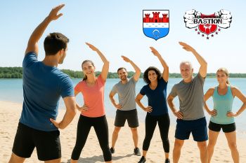 plaża, grupa osób podnosi ręce w ćwiczeniach