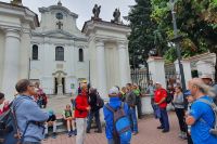 Grupa kilkunastu osób przed zabytkowym kościołem.