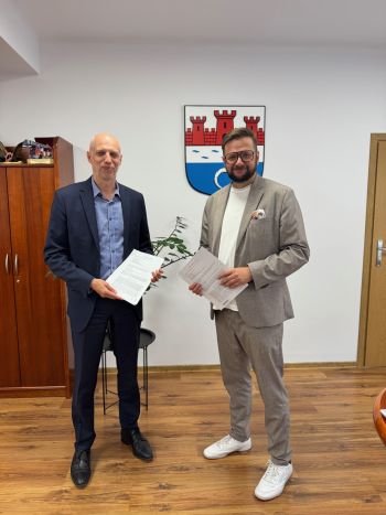 wykonawca i burmistrz uśmiechnięci pozują do zdjęcia, gabinet burmistrza