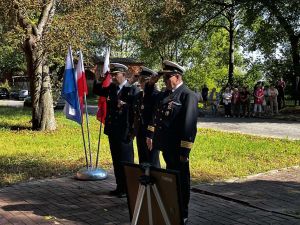 tzy osoby w mundurach i białych czapkach salutuje