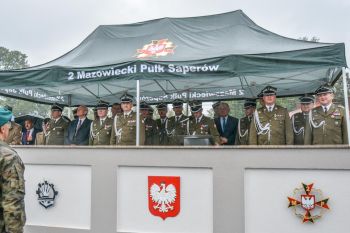 osoby stojące pod namiotem, pada deszcz,