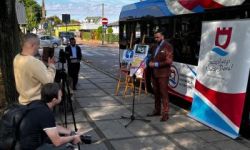 Burmistrz mówi do mikrofonu, mężczyzna z kamerą, autobus komunikacji miejskiej