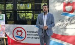 mężczyzna stoi przed autobusem, mówi do mikrofonu