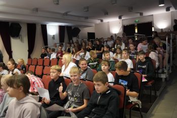 dzieci na sali kinowej w NOK-u, dorośli opowiadają o instrumentach