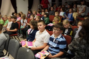 dzieci na sali kinowej w NOK-u, dorośli opowiadają o instrumentach