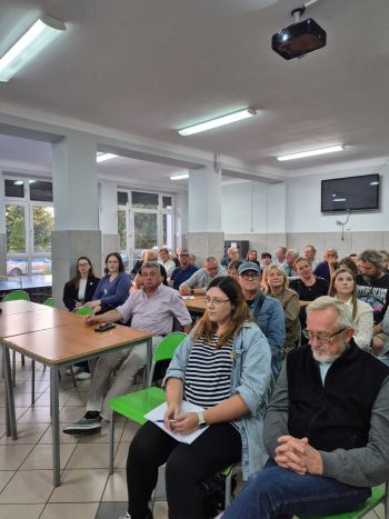 sala, osoby siedzące na krzesełkach,