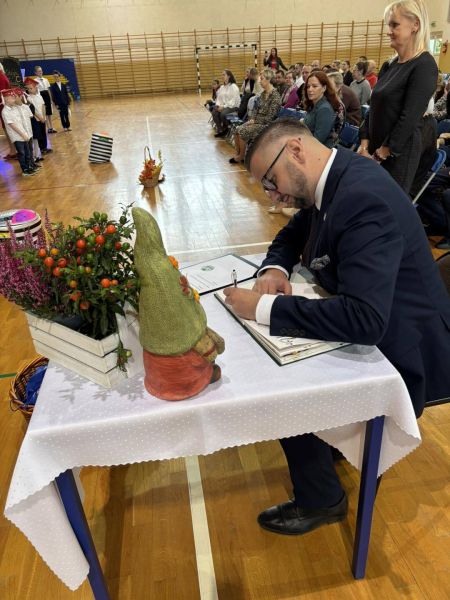 burmistrz wpisujący się do księgi pamiątkowej