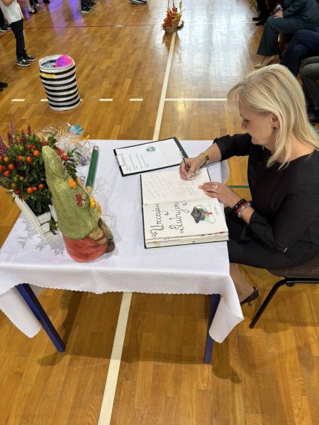 pani dyrektor wpisuje się do księgi pamiątkowej