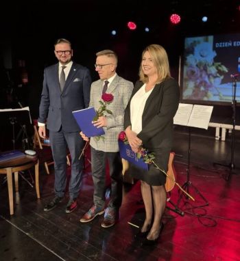 wręczanie nagród dla wyróżnionych nauczycieli, kobieta i mężczyzna z różą, obok Burmistrz