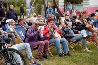 Kobiety i mężczyźni siedzący na leżakach plażowych.