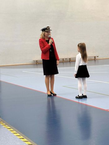 hala sportowa, dzieci ubrane na galowo, zaproszeni goście, występy z biało czerwonymi flagami