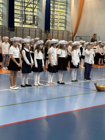 hala sportowa, dzieci ubrane na galowo, zaproszeni goście, występy z biało czerwonymi flagami