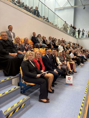 hala sportowa, dzieci ubrane na galowo, zaproszeni goście, występy z biało czerwonymi flagami