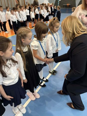 hala sportowa, dzieci ubrane na galowo, zaproszeni goście, występy z biało czerwonymi flagami