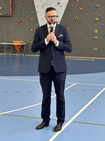hala sportowa, dzieci ubrane na galowo, zaproszeni goście, występy z biało czerwonymi flagami