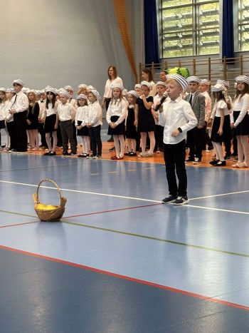 hala sportowa, dzieci ubrane na galowo, zaproszeni goście, występy z biało czerwonymi flagami