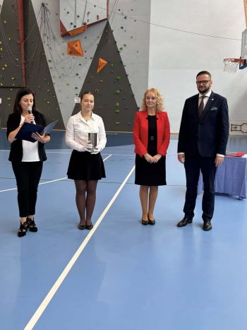 hala sportowa, dzieci ubrane na galowo, zaproszeni goście, występy z biało czerwonymi flagami