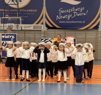 hala sportowa, dzieci ubrane na galowo, zaproszeni goście, występy z biało czerwonymi flagami