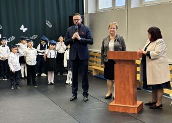 sala gimnastyczna, dzieci ubrane na galowo, dekoracja ślubowania, zaproszeni goście