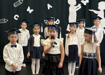 sala gimnastyczna, dzieci ubrane na galowo, dekoracja ślubowania, zaproszeni goście