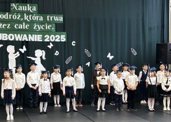 sala gimnastyczna, dzieci ubrane na galowo, dekoracja ślubowania, zaproszeni goście